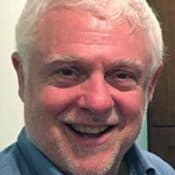 Smiling man with short white hair.