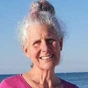 Smiling person with ocean background.