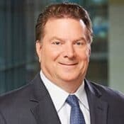 Smiling man in suit and tie.
