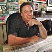 Man sitting at desk with blueprints.