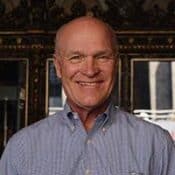 Smiling man in striped shirt indoors.