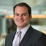 Smiling man in a suit and tie.