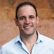 Smiling man in a light blue shirt.