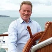 Man steering a ship at sea.
