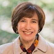 Smiling person with short brown hair.