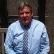 Man in blue shirt and striped tie.