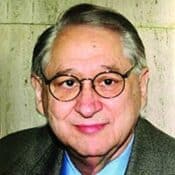 Elderly man with glasses and gray hair.