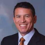 Smiling man in suit and tie.