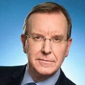 Man wearing glasses against blue background.