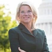 Smiling woman in professional attire outdoors.