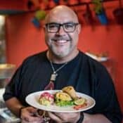 Man holding a plate of assorted food.